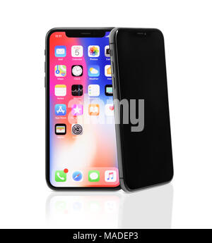 Two Apple iPhone X, large screen smartphones, product still life, one iPhone is leaning on another. The phones ares isolated on white studio backgroun Stock Photo