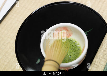 Japanese Matcha powdered green tea sampling cup with a bamboo whisk, tea tasting ceremony in Uji, Kyoto Prefecture, Japan