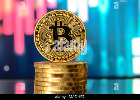 Bitcoin on top of Money stack, against blurry background Stock Photo