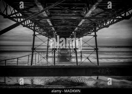 Underneath the pier at Southport in Merseyside England showing the construction ironwork. Stock Photo