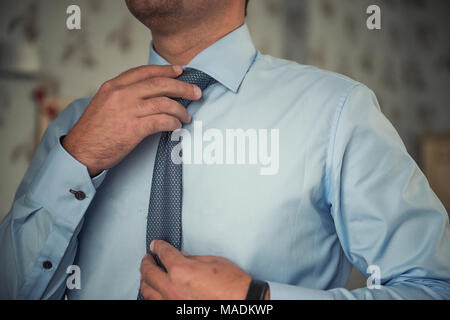 Man adjusting his necktie Stock Photo