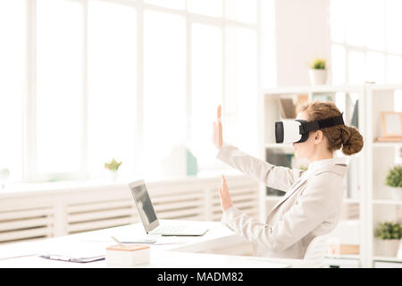 Businesswoman gesturing while using virtual reality simulator Stock Photo