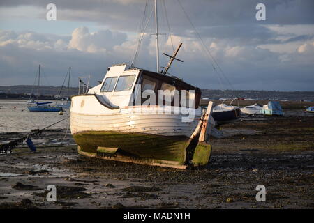 WAITING FOR THE TIDE TO TURN - BOAT AT LOW TIDE, LANGSTONE HARBOUR, PORTSMOUTH, UK Stock Photo