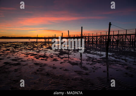 Sunset across old jetty in Poole harbour Stock Photo