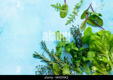 Food background. Various summer green vegetables, spices and fresh herbs on blue concrete background. Copy space, top view flat lay background. Stock Photo