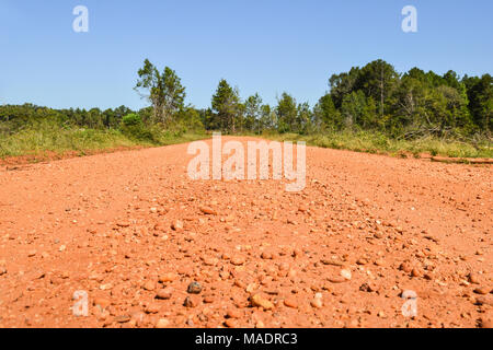 low angle perspective photo of a red gravel road in Alabama Stock Photo