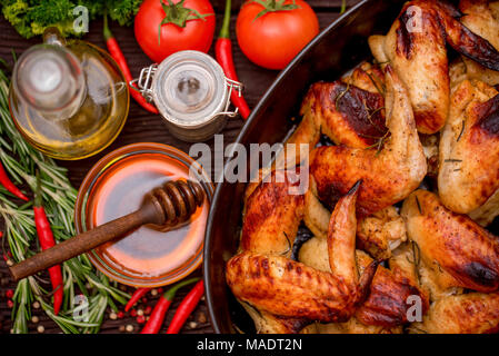 Baked chickens wings covered in honey, vegetables Stock Photo