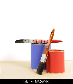 Blank white wall with blue and red cans of paint and paint brushes.  Space for copy. Stock Photo
