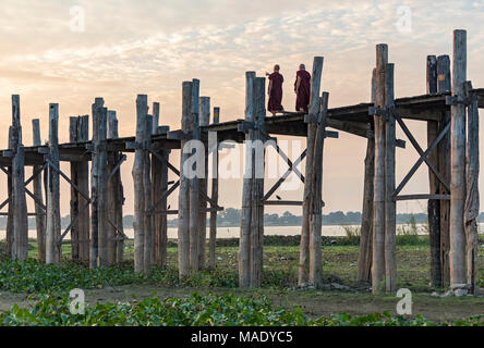 Buddhist monks walk on the U Bein Bridge in Amarapura near Mandalay, Burma (Myanmar) Stock Photo