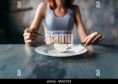 Female person against plate with a slice of apple Stock Photo