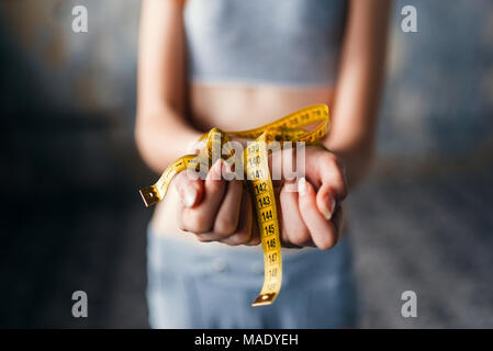 Skinny female hands are tied with measuring tape Stock Photo