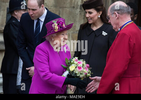 Windsor, UK. 1st April, 2018. The Queen greets the Dean of Windsor, the Rt Revd David Conner KCVO, after being presented with traditional posies of flowers by Amelia Vivian and Madeleine Carleston, both aged 6, following the Easter Sunday service in St George's Chapel in Windsor Castle. Credit: Mark Kerrison/Alamy Live News Stock Photo