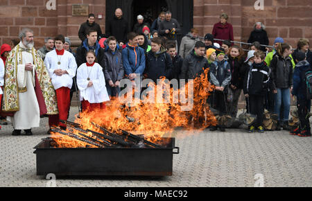 01 April 2018, Germany, Freiburg: Kids hold Easter swams into the fire and make them glow in front of the church. Easter swams are a mushroom type that grow on trees and children look for them in the forest as a Easter tradition. After being blessed by the priest, children go around with glowing and smoking swams to people's homes. This tradition aims to bring the Easter fire to people's homes. Usually children get presents for completing this task. Photo: Patrick Seeger/dpa Credit: dpa picture alliance/Alamy Live News Stock Photo