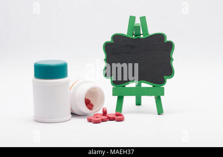 wooden easel and a Bottle of spill pills. isolated on white background. Stock Photo