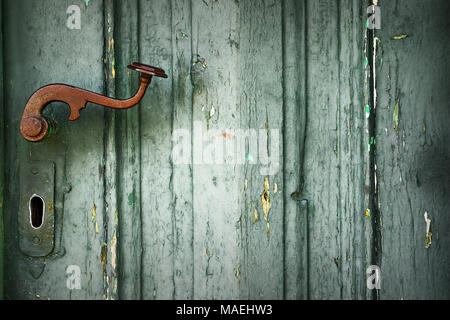 detail of old door with metallic rusty latch on green wood plank Stock Photo