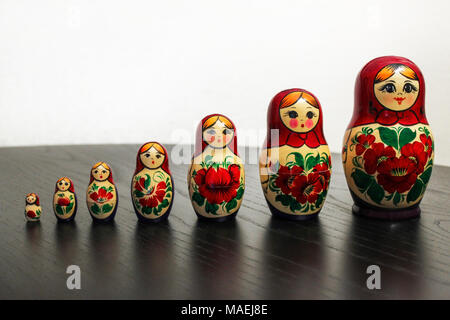 Russian nesting dolls in a row on a black wooden table Stock Photo