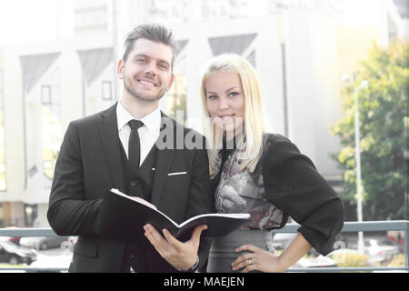 couple of employees reading documents standing near the office Stock Photo