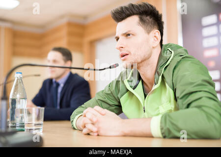Bearded Sportsman Answering Questions of Journalists Stock Photo