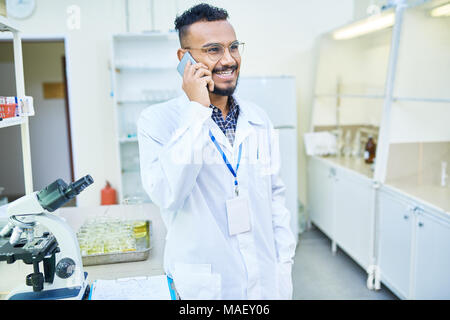 Ecstatic Arabian doctor talking on phone Stock Photo