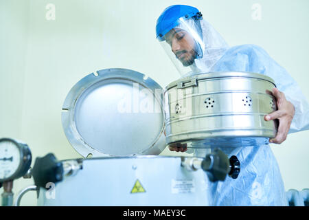 Laboratory assistant putting container into centrifuge Stock Photo