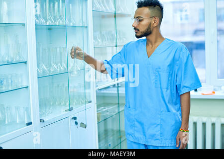 Young handsome chemist working in the lab Stock Photo - Alamy