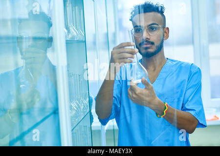Modern lab technician working with glassware Stock Photo