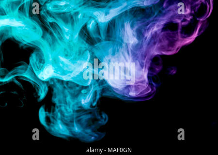 Thick blue, green   and pink colorful smoke  on a black isolated background. Background from the smoke of vape Stock Photo