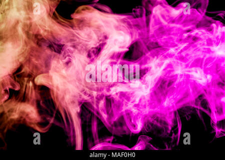 Thick  yellow  and pink colorful smoke  on a black isolated background. Background from the smoke of vape Stock Photo