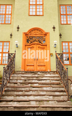 Old building entrance with metallic handrails and wooden door in Oslo, Norway. Stock Photo