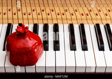 red pomegranate on the piano keys background Stock Photo