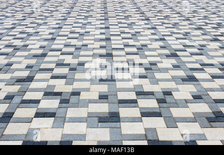 Sidewalk in the park is paved with multicolored stone blocks Stock Photo