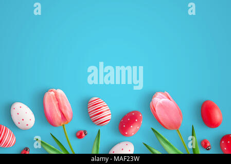 Eggs and tulip flowers on blue surface. Ladybug colorful eggs and decorations. Copy space for text. Stock Photo