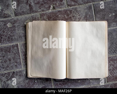 Old school copy book, abandoned in dust. Squared paper. Stock Photo