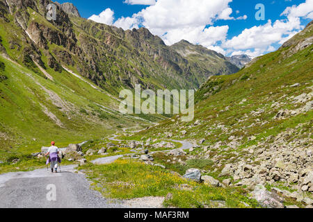 A female senior hiker hiking through the green Jamtal in summer near the Jamtal Hut in the Paznaun Valley near Galtur in Austria. Stock Photo