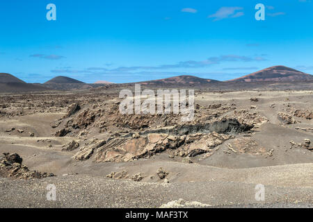 Lava and crater landscape of Timanfaya in Lanzarote, Spain with blue sky. Stock Photo