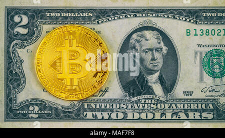 Physical version of Bitcoin new virtual money and banknotes of two dollar. Exchange bitcoin for a dollar. Conceptual image for worldwide cryptocurrenc Stock Photo