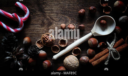 Nuts on a wooden table. Hazelnuts in the shells and shelled. A wooden spoon and nuts on brown table. Stock Photo