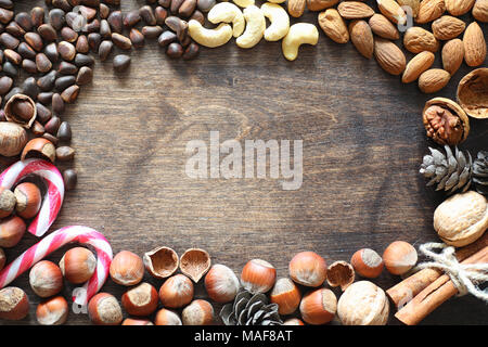 Different nuts on a wooden table. Cedar, cashew, hazelnut, walnuts and a spoon on the table. Many nuts are inshell and chistchenyh on a wooden backgro Stock Photo