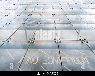 Overhead through glass view of ambulance only parking space on British hospital entrance. Stock Photo