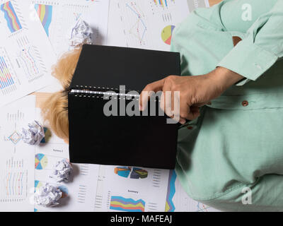 businessman sleeping at his workplace with crumpled papers around Stock Photo