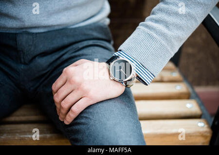 Stylish man in gray jumper, elegant business man's hand with fashion no brand wrist watch, men fashion and accessories closeup shot Stock Photo
