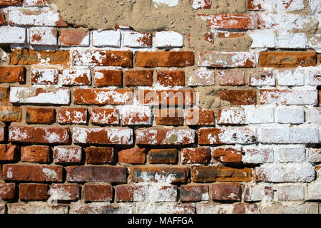 Wall of an old red brick in places whitewashed with lime Stock Photo