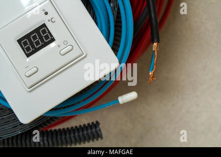Heating floor system wires, cables and control panel. Renovation and construction concept. Comfort house. Stock Photo