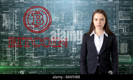 Bauty business woman standing in suit with Bitcoin Logo to illustrate the use of bitcoin for trading or money transfer. Stock Photo