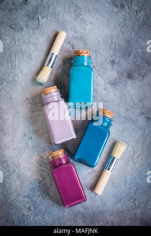 Brushes and paints on the concrete background, drawing concept, toned Stock Photo