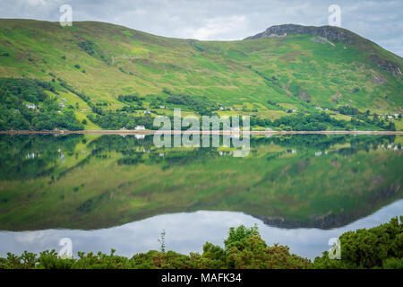Mirror like reflections over Loch Broom in a cloudy morning Stock Photo