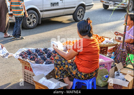 Woman selling grapes on the street in Yangon, Myanmar Stock Photo