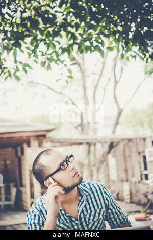 Businessman is thinking about something with pencil on head while working at home. Stock Photo