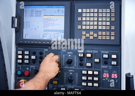 factory engineer controlling and pressing important technology button at control panel of an automatic machine in the manufacturing. Stock Photo