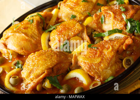 Moroccan cuisine: Spicy chicken with salted lemons, onions and green olives close-up on a plate. horizontal Stock Photo